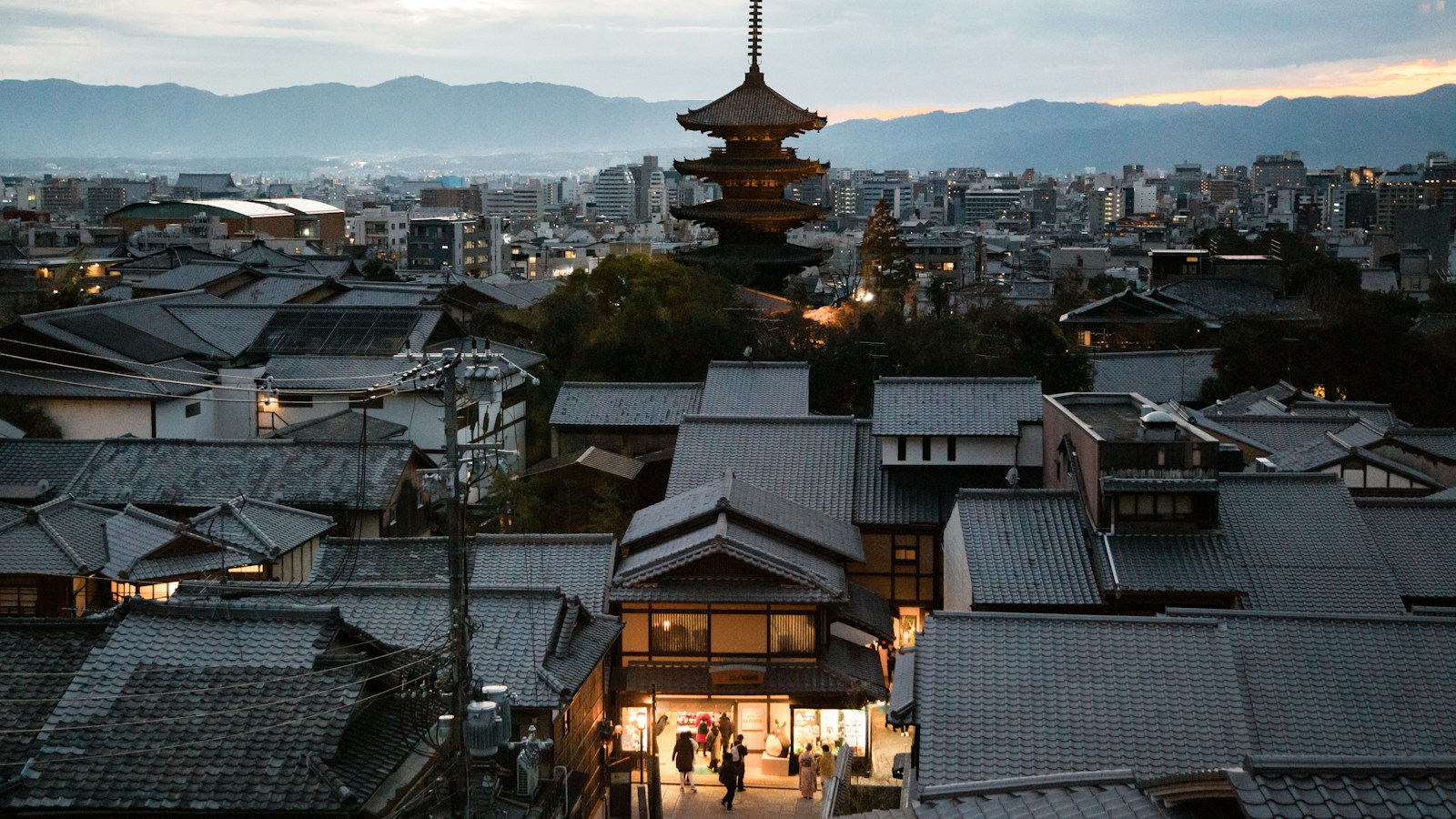 Traditional Kyoto rooftops and a pagoda at dusk